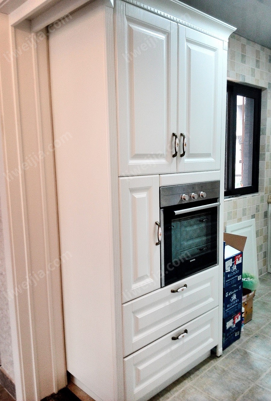 烤箱的设计也堪称厨房的点睛之笔，出于空间和光线的考虑，厨房窗户位置没有打造常规地柜，而是在靠近厨房门的空间打造了收纳能力更强的立型柜，烤箱完美地集成在其中。