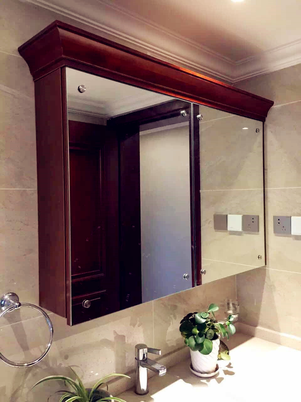 设计师独具匠心，将传统的实木浴室柜门用两块镜面代替。真可谓一举三得，既满足了洗漱时的需求，又拥有强大的储物功能，还利用大大的镜面使得空间更加明亮，洗手间的视觉面积也变大。